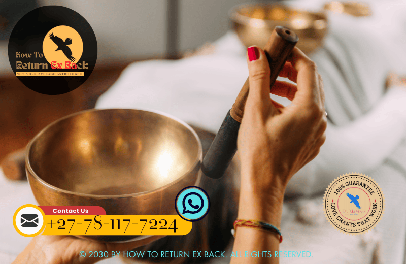 A couple sitting in a serene environment, using a singing bowl to perform a sound healing ritual aimed at releasing emotional blockages.