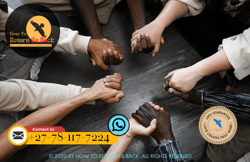 A group of people holding hands in a community circle, representing the power of communal healing rituals