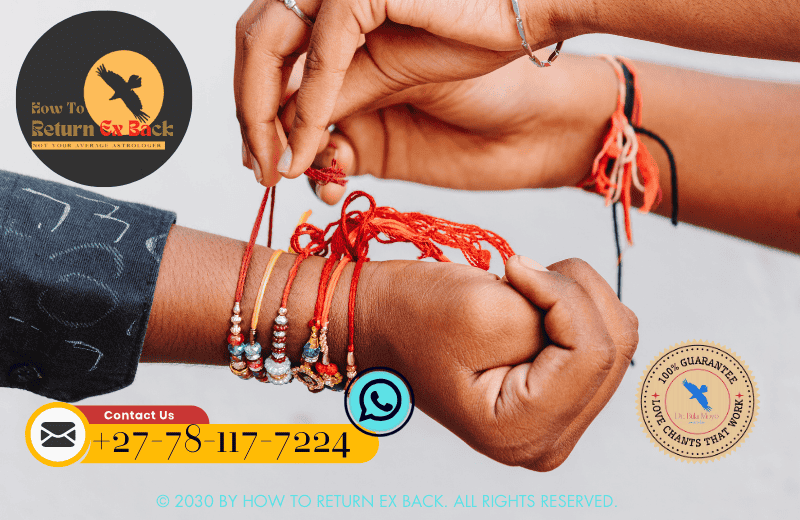 A hand tying a red cord in a knot, representing the union of two souls during a love binding ceremony.