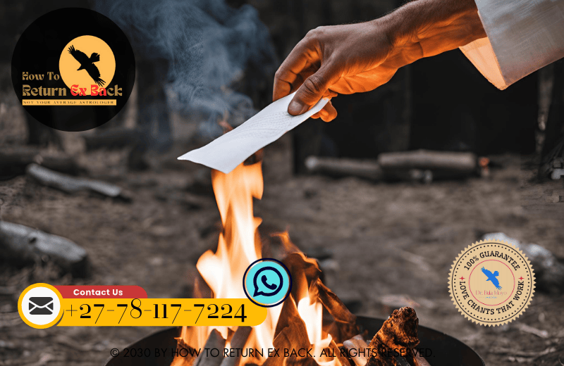 A person releasing a paper into a fire during a burning ceremony ritual, symbolizing the release of past hurts.